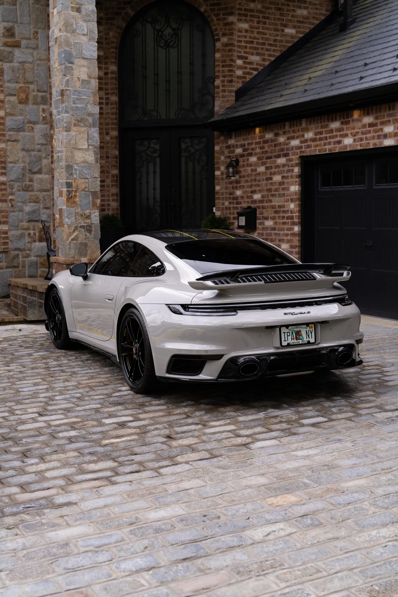 Silver Porsche 911 parked on a cobblestone driveway